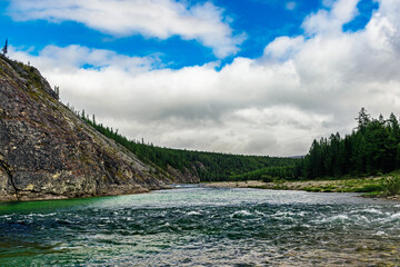 northern river flowing among the rocks in a forest area