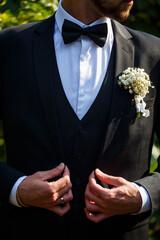 Stylish man groom buttoning a button on his jacket