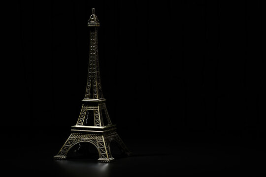 Miniature of the Eiffel Tower. In the dark - a ray of light from above Eiffel Tower in the New Year. Macro photography. Photo for a postcard for the new year of France, Paris.