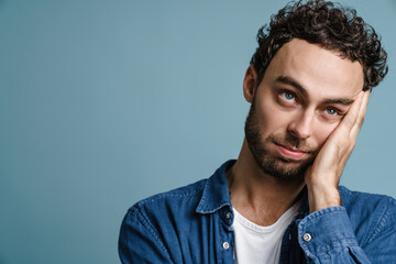 Tired unshaven handsome guy posing and looking upward