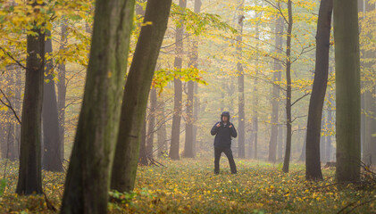 Hiking man in fog at autumn forest