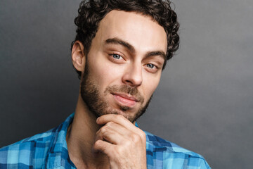 Unshaven pleased guy posing and looking at camera