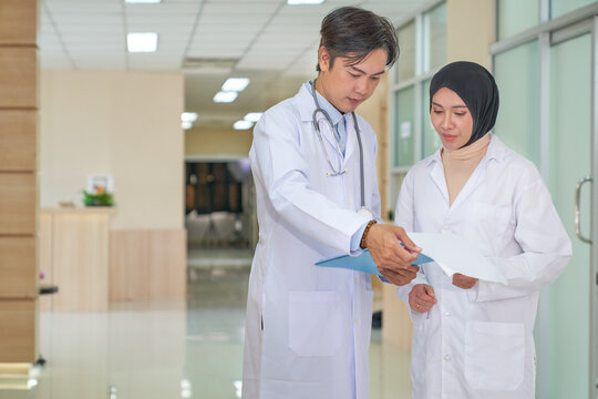 Two doctors are discussing with patient case in labby of hospital