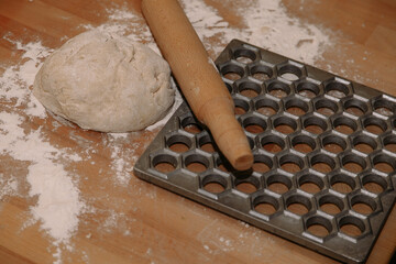 Woman sculpts homemade dumplings bear ears in the kitchen. Modeling dumplings closeup. Female hands sculpt dumplings.