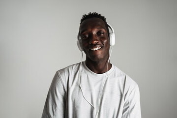 Happy african american guy listening music with headphones and smiling