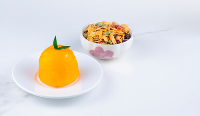 Focus at orange soft fudge cake with toppings on white marble tabletop