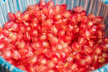 Pomegranate seeds in a blue bowl