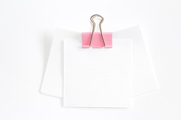 White sheets for notes fastened by a clip. A place for text.