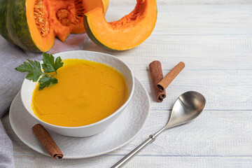 Fresh pumpkin cream soup with sour cream. Autumn lunch concept. A dietary, healthy dish.
