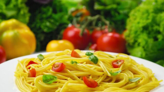 Plate of cooked italian pasta, spaghetti with tomatoes and basil leaves with copy space