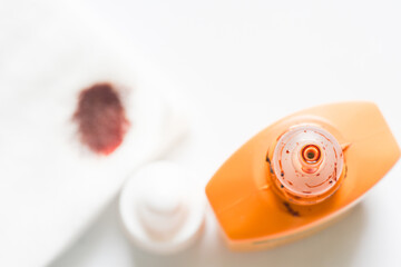 Betadine bottle with cotton puff on white background