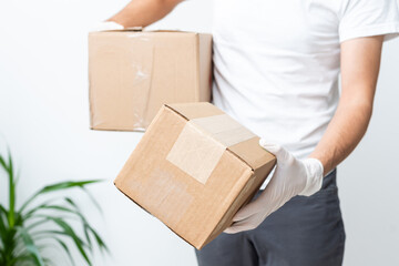 Delivery man holding cardboard boxes in medical rubber gloves and mask. copy space. Fast and free Delivery transport . Online shopping and Express delivery . Quarantine