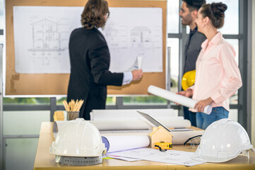 Obraz premium Close up engineer helmet, tools and many equipment with group of Caucasian engineer at the background.