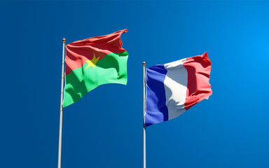 Beautiful national state flags of Burkina Faso and France together at the sky background. 3D artwork concept.