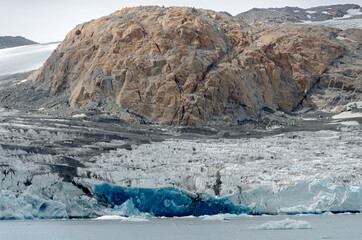Front of a melting glacier. A mountain that some years ago was covered by ice now is visible. ago