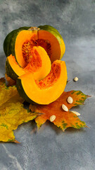 Fresh pumpkin on a gray background with pumpkin seeds. Autumn lunch concept. On a wooden background. Healthy dietary product.