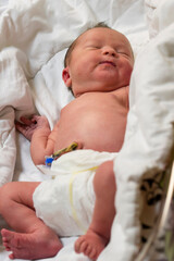 A newborn with an umbilical cord lying in a maternity hospital.