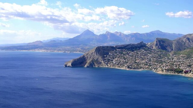 Penon de Ifach viewpoint, Penyal d'Ifac, Pe&ntilde;on de Ifachs Natural Park. Time-lapse, timelapse. Ifach penon and Calpe or Calp coast in the south of Spain in fast motion clouds and boats.