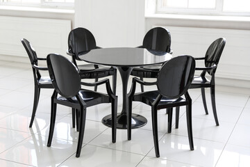 black chairs around the table are in white room