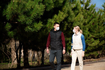 Fototapeta premium Young European man and woman in protective disposable medical mask walking outdoors afraid of dangerous NCoV 2019 influenza coronavirus mutated and spreading in China