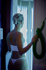Beautiful woman making uv ray treatment in the solarium