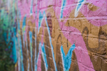 Generic rustic brick wall graffiti style painting on a wall with a shallow depth of focus.