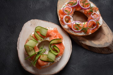 Bagel sandwich with salmon, cream cheese, cucumber, and onions