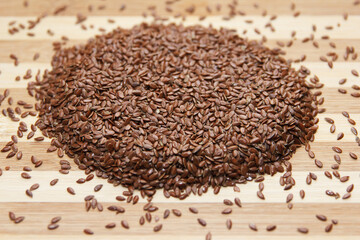 Linseed raw seeds sprinkled on a wooden board