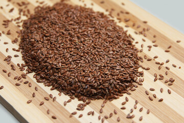 Linseed raw seeds sprinkled on a wooden board
