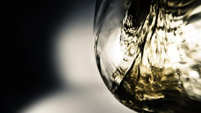 Creative macro slow motion video of white wine pouring into a glass. Glass with pouring white wine close-up. Old retro grunge vintage style.