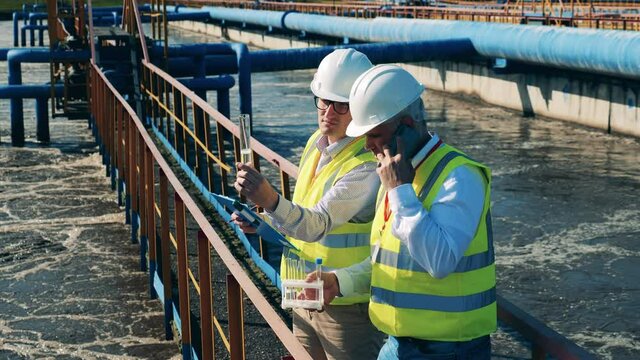 Wastewater treatment concept. Engineers are discussing a probe of the wastewaters