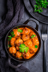 Meatballs with tomato sauce in black pan