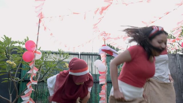 Indonesian girls took part in a sack race supported by spectators on the field during independence day celebration of indonesia