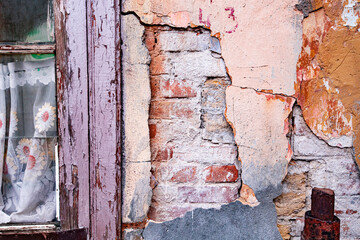 old window in an abandoned building. old grunge wall with cracked paint, bricks and cracks