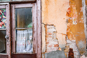 old window in an abandoned building. old grunge wall with cracked paint, bricks and cracks