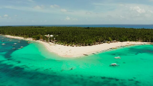 Tropical island in the ocean with palm trees on white sand beach. Daco island, Philippines. Summer and travel vacation concept