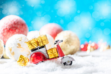 Vintage red toy motorbike with christmas gifts in the snow. Xmas and Happy New Year theme. © Gulsina