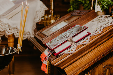 rite of sacrament of epiphany in church. lighted candles near bible on altar