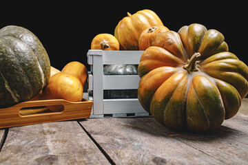 Pile of pumpkins in wooden box on wooden board