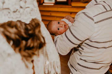 baby hand in arms of godfather. rite of sacrament of epiphany in church