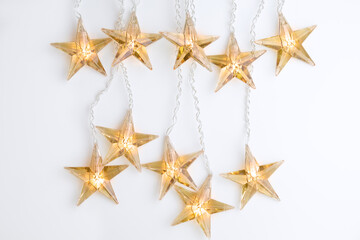 Top view of star shaped Christmas lights against white background with copy space