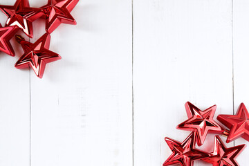 Top view of red christmas stars on a white wooden table with copy space