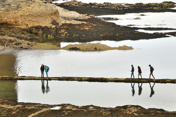 seaside landscape with people strolling just before sunset in saint andrews