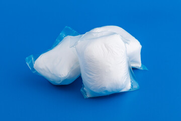 Capsules with washing powder, on a blue background. Powder, drugs concept. Copy space