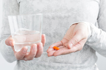 Girl holding Pill and glass of water. Medicine. treatment. Capsules Vitamin And Dietary Supplements.