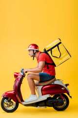 side view of delivery man with backpack riding scooter on yellow © LIGHTFIELD STUDIOS