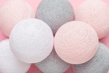Pink, grey and white balls garland on a pastel background, home decoration