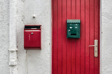 Buzones de colores sobre puerta roja