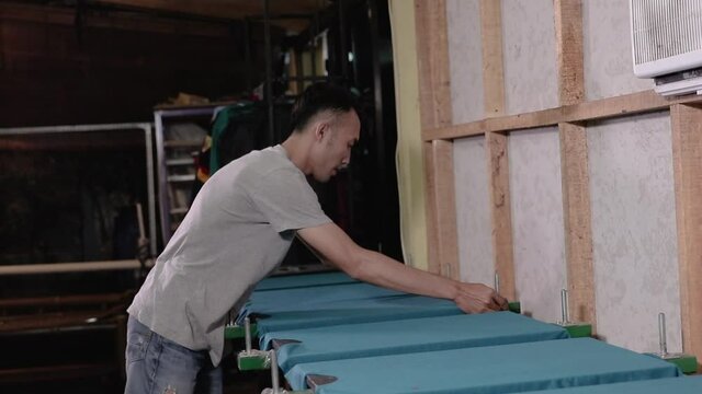 Man preparing silkscreen by hand for used to work printing t-shirts