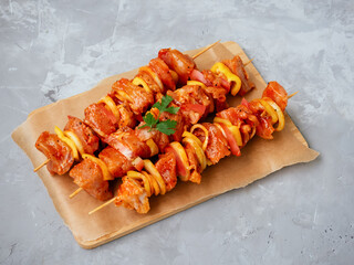 Uncooked marinated and rubbed chiken or turkey shish kebabs on skewers with onion, pepper and...